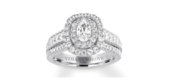 White gold engagement ring with oval center diamond and round diamond halo and side stones in a pave setting.